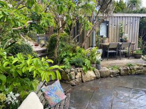 a garden with a table and chairs and plants at Spacious Studio by the sea, Garden & Parking in Marazion +27 photos