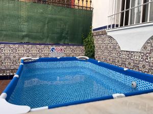 a blue swimming pool in front of a building at Villa Alhelí del Aljarafe in Mairena del Aljarafe