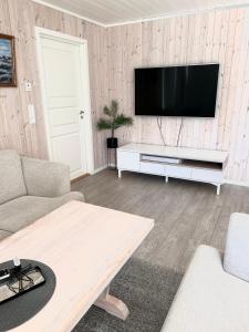 a living room with a flat screen tv on a wall at Ocean View Cottage in Alta