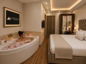 a woman in a bath tub in a hotel room at Hadayek Al-Ahram Guest House - حدائق الاهرام جيست هاوس in Giza +82 photos