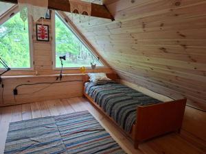 a bedroom in a log cabin with a bed and a window at Józefowa Chata in Rudnik