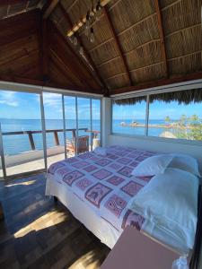 ein Schlafzimmer mit einem Bett und Meerblick in der Unterkunft Isla Quimera Adults Only Beachfront Retreat in San-Blas-Inseln