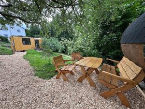 a wooden picnic table and chairs in a backyard at Schlaffass im Apfelhain in Hohenraunau