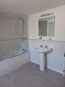a bathroom with a sink and a shower and a mirror at 17 French Street in Teignmouth +28 photos