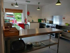 a kitchen with a table in the middle of it at Hartfield House Hostel in Applecross