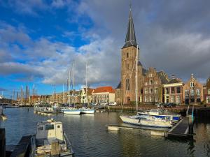 a group of boats docked in a harbor with a church at Een Nije Dei in Arum