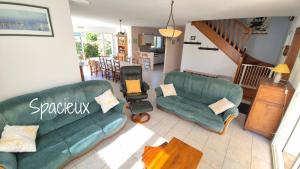 a living room with two green couches and a table at Maison 5 chambres, 3 SdB, proche plage in Arzon