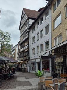 a city street with buildings and tables and chairs at Modern & Quiet City Apartment in Hannover