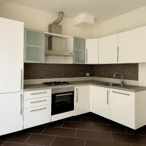 a white kitchen with white cabinets and a sink at Ground floor house in Castel Bolognese