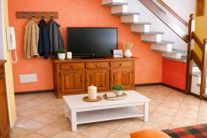 a living room with a tv and a table at Casa Maria in Pettenasco