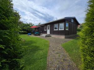 a small black house with a grass yard at Ferienhaus Parnet in Neudorf