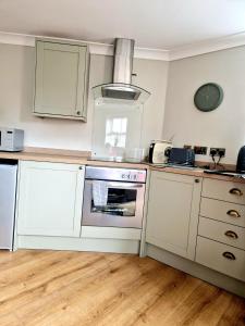 a kitchen with white cabinets and an oven at The Stables Annexe in Patrington