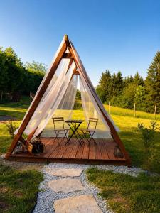a tent with two chairs and a table in a field at Lesná Obývačka in Stará Huta