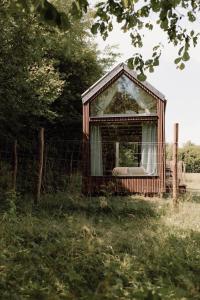 an old house with a window in a field at Lesná Obývačka in Stará Huta