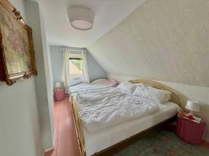 a bedroom with a bed with white sheets and pillows at Dahlienhof in Wittenberge
