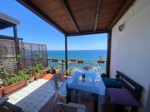 a dining room with a view of the ocean at Appartamento Teocle beach in Giardini Naxos