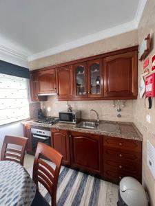 a small kitchen with wooden cabinets and a sink at Monte Gordo T1 - Estrela do Mar in Monte Gordo +9 photos
