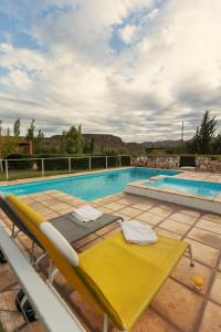 a pool with a yellow lounge chair next to a swimming pool at La Agustina Complejo Apart in Valle Grande