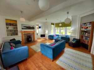 a living room with two blue couches and a fireplace at Hartfield House Hostel in Applecross