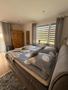 a bedroom with a large bed and a window at Sosnowe Zacisze in Zwierzyniec