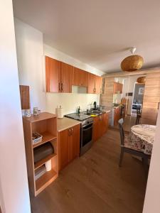 a large kitchen with wooden cabinets and a table at Sosnowe Zacisze in Zwierzyniec