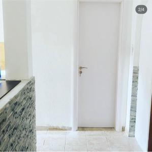 a white door in a room with a tile floor at Apartmani Ljilja in Zgrada