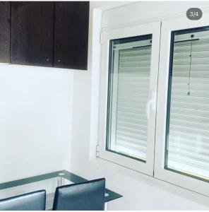 a kitchen with two windows with blinds on them at Apartmani Ljilja in Zgrada
