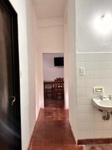 a hallway with a bathroom with a sink and a table at El Descanso APART in Libertador General San Martín +11 photos