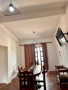 a dining room with a table and chairs and a television at El Descanso APART in Libertador General San Martín