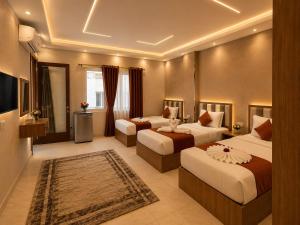 a hotel room with two beds and a television at Grand City Hotel River View in Cairo