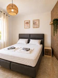 a bedroom with a large bed with a black headboard at Monte Liza Apartments in Dobra Voda