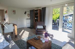 a living room with a couch and a table at Champagnehuisje in Voorthuizen