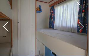 a small room with a window with a curtain at Champagnehuisje in Voorthuizen