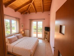 a bedroom with a bed and a large window at Casa Rosa Ammoudia in Ammoudia