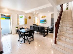 a dining room and living room with a table and chairs at Villa Coralys - Plage - Cozy in Schœlcher