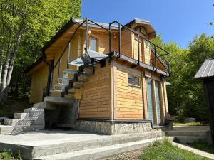 a wooden building with stairs on the side of it at Stanetestruzhes in Prizren