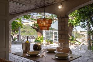 a table with plates and wine glasses on a patio at Beach Suite Nina in Rab