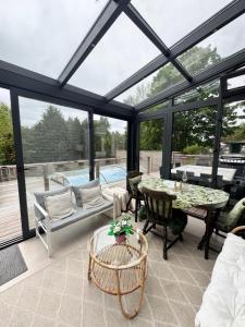 a conservatory with a table and chairs on a patio at The Cheerful Villa In Perstorp in Perstorp