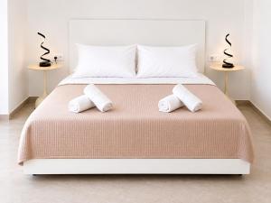 a bedroom with a bed with two towels on it at Maxa Residences - Free Airport Shuttle in Artemida