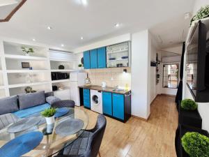 a kitchen and living room with blue cabinets at Apartments Sandra in the historical center of the city in Supetar