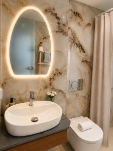 a bathroom with a sink and a mirror at Maxa Residences - Free Airport Shuttle in Artemida +5 photos