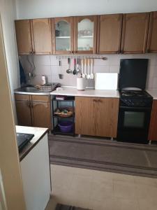 a small kitchen with wooden cabinets and a stove at Apartman Kali Leskovac in Leskovac +5 photos