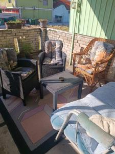 a patio with three chairs and a table and a tableablish at Apartman Kali Leskovac in Leskovac