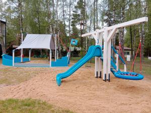 a playground with two swings and a slide at Sailor Apart Okuninka in Okuninka