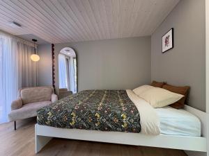 a bedroom with a bed and a chair at MetsaMaja in Hiiumaa