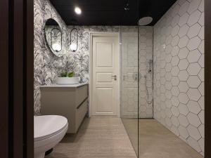 a bathroom with a toilet and a glass shower at MetsaMaja in Hiiumaa +7 photos