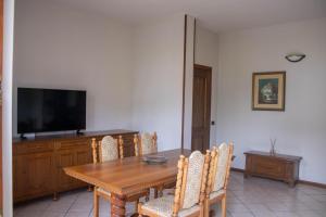 a dining room with a wooden table and a flat screen tv at Alveare 27 in Monticelli Brusati