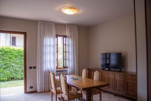 a dining room with a table and a television at Alveare 27 in Monticelli Brusati