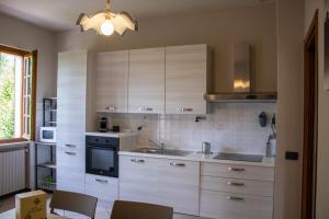 a kitchen with white cabinets and a stove at Alveare 27 in Monticelli Brusati +27 photos