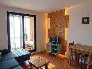 a living room with a couch and a tv and a table at Appartement 200m plages in Six-Fours-les-Plages